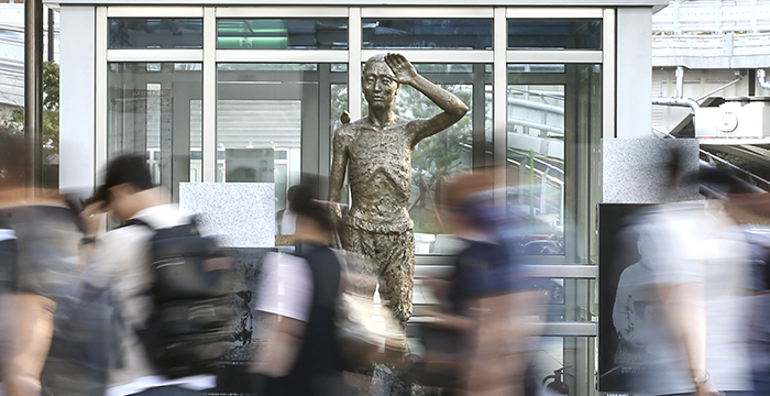 Kim Eun-sung and Kim Seo-Kyung, the two artists who designed the statue symbolizing colonial wartime forced laborers, say, 'The pickax stands for the pain of extreme labor, the left hand shading the sun represents fear, the eyes gazing into the distance portray hope, and the bird on the shoulder symbolizes freedom and peace.'